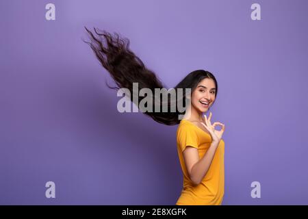 Indian woman posing with long flying hair showing okay gesture Stock Photo