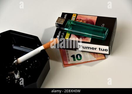 cigarettes under $10 In this photo illustration a 10 euro bill under a cigarette packet and a  lighter seen displayed next to a burning cigarette in a black ashtray.Some  brands of cigarettes will see their