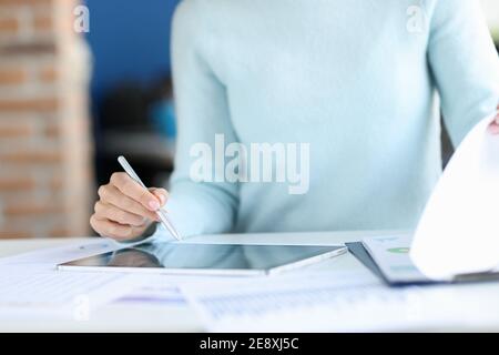 Business woman holding stylus in hands over tablet closeup Stock Photo