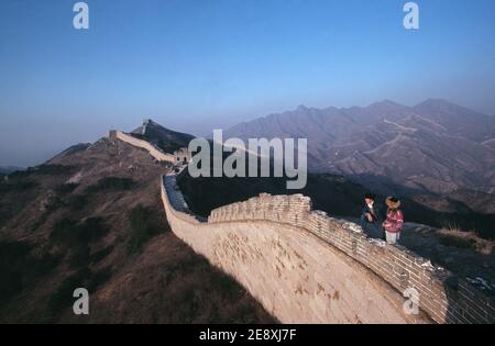 China. Jinshanling. Young tourist couple standing on Great Wall of China. Stock Photo