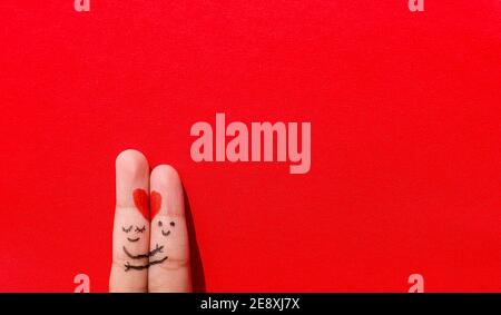 Valentines Day background. A happy couple with Red heart art on finger on an isolated colorful Background With Space. Stock Photo