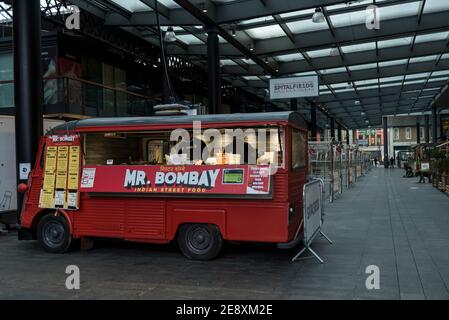 London, UK.  1 February 2021. An Indian street food vendor in front of empty market stalls at Spitalfields Market in East London as concern over the severity of a South African Covid-19 variant in the UK continues.  The UK government has also just announced that 9.2m people have been vaccinated.  Pre-pandemic, market stalls would be open and the restaurants crowded with locals and foodie tourists. Credit: Stephen Chung / Alamy Live News Stock Photo