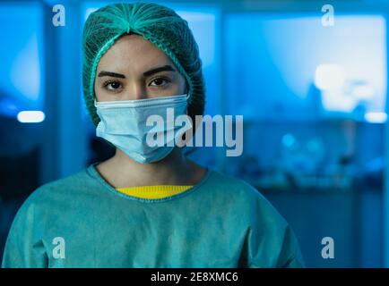 Young female doctor wearing personal protective equipment inside medical laboratory during corona virus pandemic - Health care worker concept Stock Photo