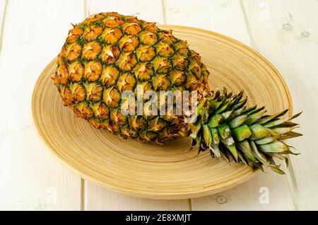 Exotic fruits. Ripe sweet ripe pineapple on wooden background. Photo Stock Photo