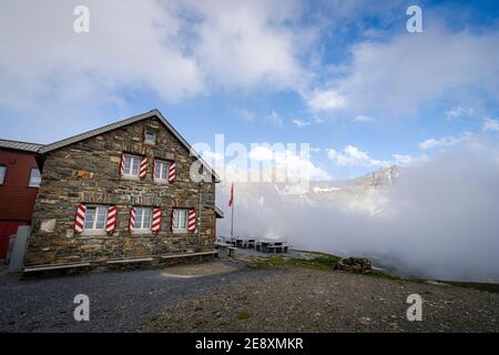 Muttsee Hutte mountain hut in the mist, Limmernsee, Canton of Glarus, Switzerland Stock Photo