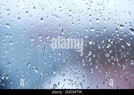 rain droplets on glass over calm colorful background. abstract creative backdrop Stock Photo