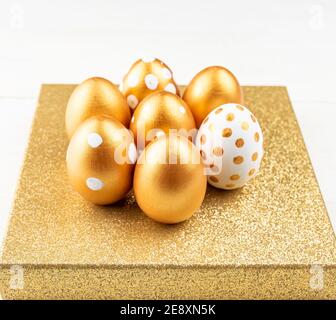 Easter festive decoration.Close up of easter eggs colored with golden paint on glittering podium. Various dotted designs Stock Photo