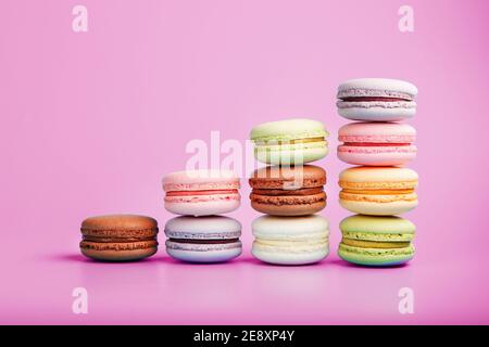 Colorful French macaroni cookies are arranged in a pyramid on the background. Top view, free space Stock Photo