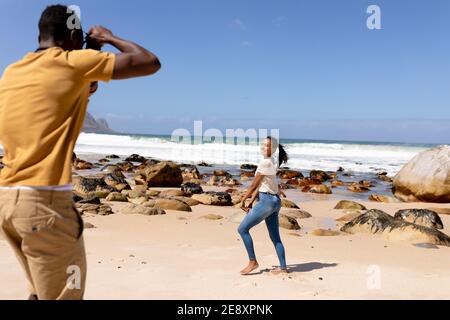 African american couple taking photos on a beach by the sea Stock Photo