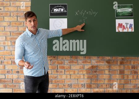 Portrait of male caucasian teacher teaching mathematics in the classroom at school Stock Photo