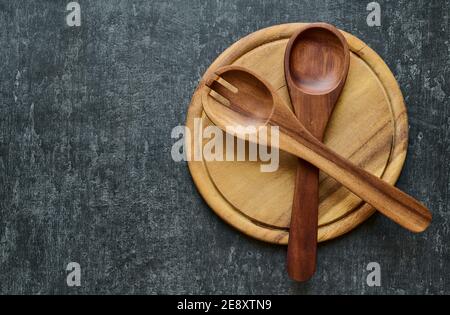 https://l450v.alamy.com/450v/2e8xtn9/kitchen-utensils-wooden-salad-spoons-lie-crosswise-on-a-round-cutting-board-vintage-style-top-view-with-copy-place-2e8xtn9.jpg