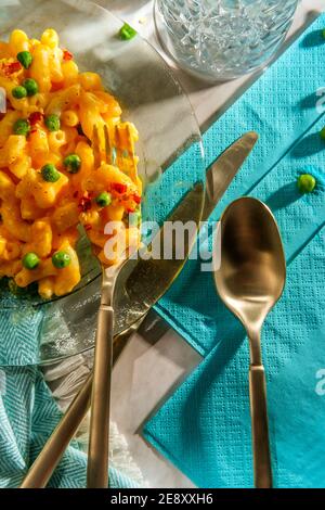 Macaroni and cheese with green peas and crushed red pepper on bright sunny day Stock Photo - Alamy