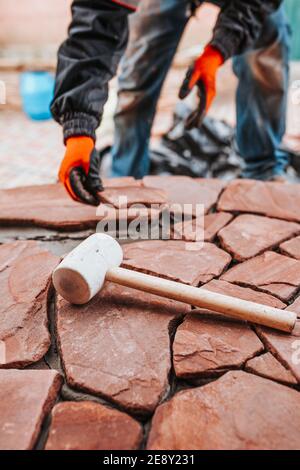 Master tiler combines pieces of natural stone when facing porch steps Stock Photo