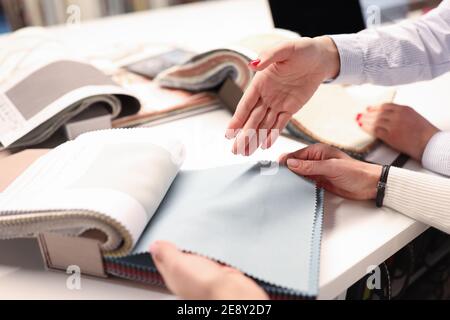 Women holding catalog and choosing fabrics closeup Stock Photo