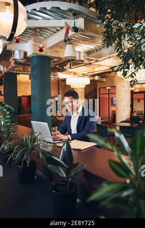 Smiling businessman checking his email in a cafe Stock Photo