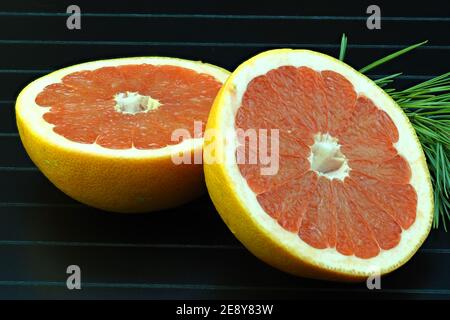Grapefruit, cut on a black background, isolated, close-up, macro. Stock Photo