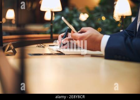 Male entrepreneur jotting down his ideas on paper Stock Photo