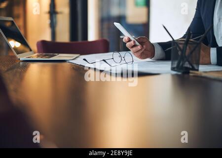 Male engineer surfing the net on his smartphone Stock Photo