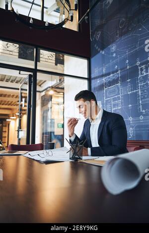 Smiling engineer using the loudspeaker mode during the talk Stock Photo