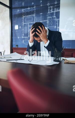 Draftsman having a severe headache in the workplace Stock Photo