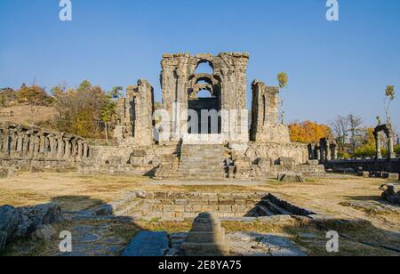 Ruins of the Martand Sun Temple under the sunlight and a blue sky in India Stock Photo