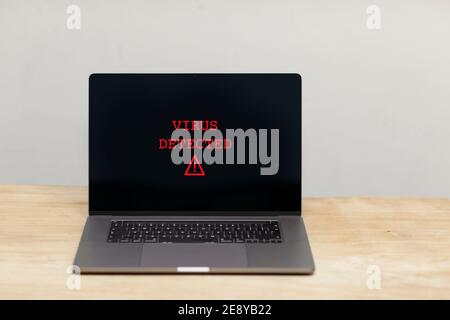 Virus dectected text and a caution warning sign in red popping up on a laptop screen. A hacked computer with bad security. Cybercrime, malware, ransom Stock Photo