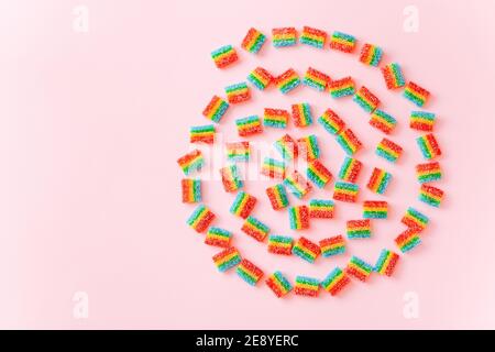 Shape of colorful swirl made from jelly candies on pink background, top view Stock Photo