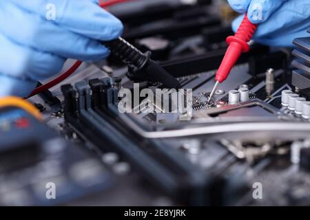 Hands in rubber gloves repairing computer closeup Stock Photo