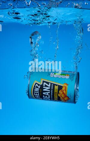 Freeze motion photo of a tin of Heinz Beanz dropped into water. Stock Photo