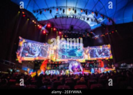 Blurred background of esports event at big arena with a lot of lights and screens. Stock Photo