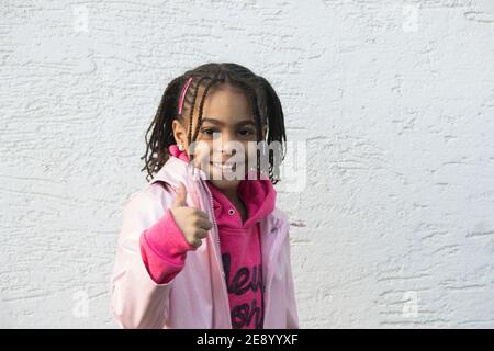 Portrait of a little mixed girl showing thumb up Stock Photo