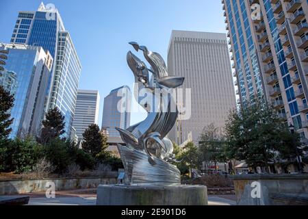 A view of the Charlotte, North Carolina, skyline in a bright blue sky as seen from Romare Bearden Park with modern sculpture. Stock Photo