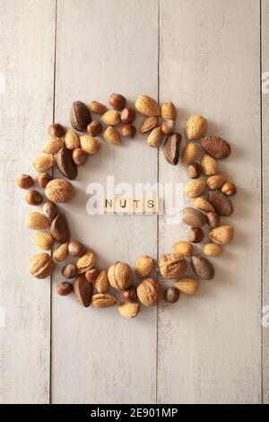Shelles almonds, walnuts, macadamia nuts, pecans, hazelnuts arranged in a circle on wooden background Stock Photo