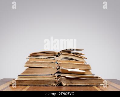 there are many old open books with bookmarks on wooden table on gray background Stock Photo