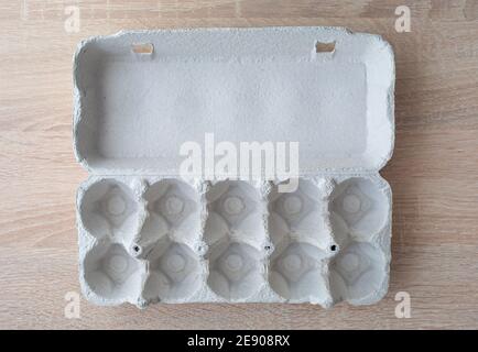 Cardboard egg box. Empty egg carton. Eggs box. Empty box of 10 eggs on a wooden table Stock Photo