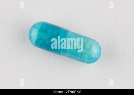 Macro image of a blue translucent tablet capsule allowing you to see the medicine inside Stock Photo