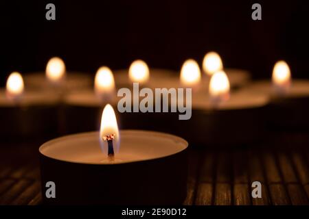 Close up of burning canndle with blurred candles in the backgorund Stock Photo
