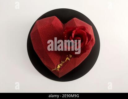 Heart shaped cherry mousse cake decorated with rose flower valentine isolated on white background Stock Photo