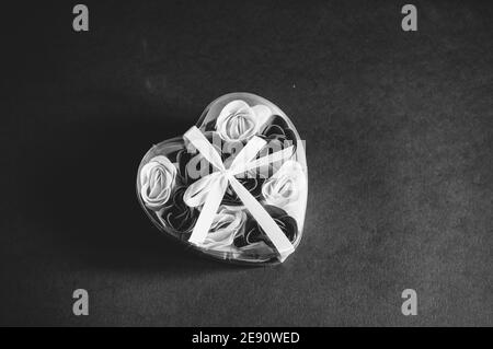 Black and white photo of a heart shaped gift box on black background Stock Photo