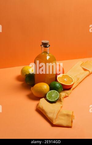 orange juice in jars with its fruits on an orange background Stock Photo