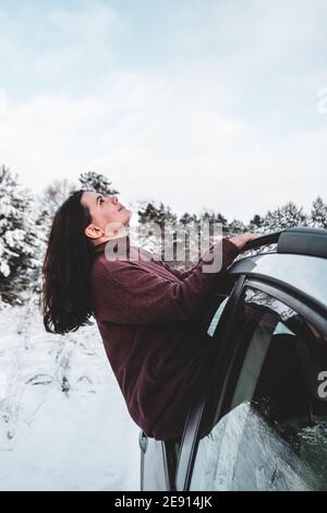 A beautiful girl looking on winter sky through the car window Stock Photo