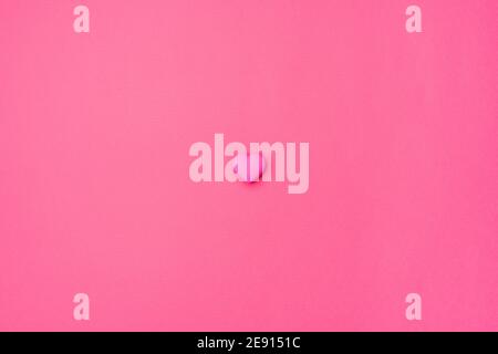 Pink heart isolated in the center on an empty colorful pink background. Symbol of love for Happy Women's, Mother's, Valentine's Day, Birthday greeting romantic postcard. Flat lay, top view, copy space Stock Photo