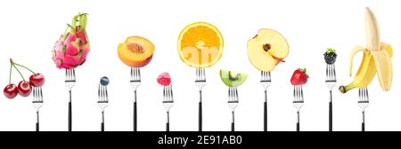 Different fruits impaled on forks against white background Stock Photo