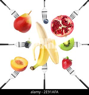 Different fruits impaled on forks against white background Stock Photo