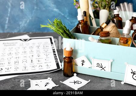 Alchemical symbols and ingredients for preparing potions on table Stock Photo