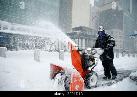 A man clears snow with a snow blower in front of the UN Building.The first nor'easter of 2021 has pummelled areas of the northern and central east coast including New York City, with over a foot of snow. Public transportation has been operating at a reduced schedule and coronavirus vaccination sites have been shut down, this possibly being the biggest storm surge since Superstorm Sandy in 2012. Stock Photo