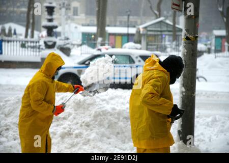 Workers clear snow from the sidewalk in Midtown.The first nor'easter of 2021 has pummelled areas of the northern and central east coast including New York City, with over a foot of snow. Public transportation has been operating at a reduced schedule and coronavirus vaccination sites have been shut down, this possibly being the biggest storm surge since Superstorm Sandy in 2012. Stock Photo