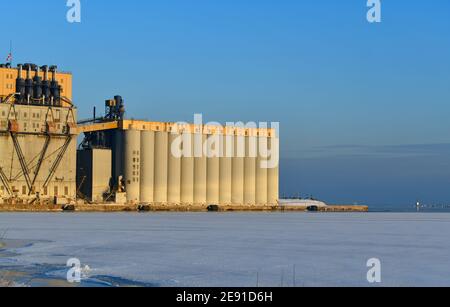 A grain elevator on a sunny day, stands by the ice filled harbor of Lake Superior, at Thunder Bay, Ontario, Canada. Stock Photo