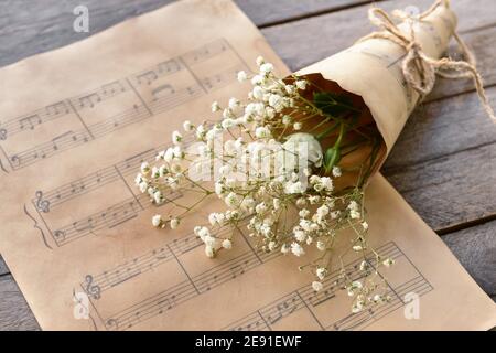Music sheets and flowers on wooden background Stock Photo