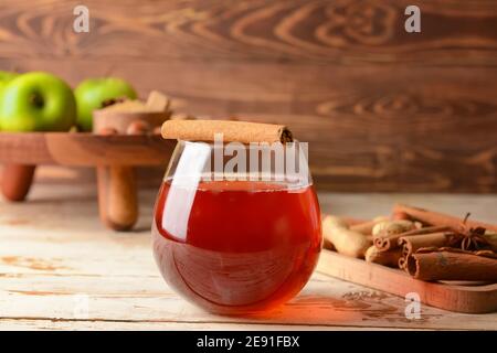 Tasty drink with cinnamon in glass on wooden background Stock Photo